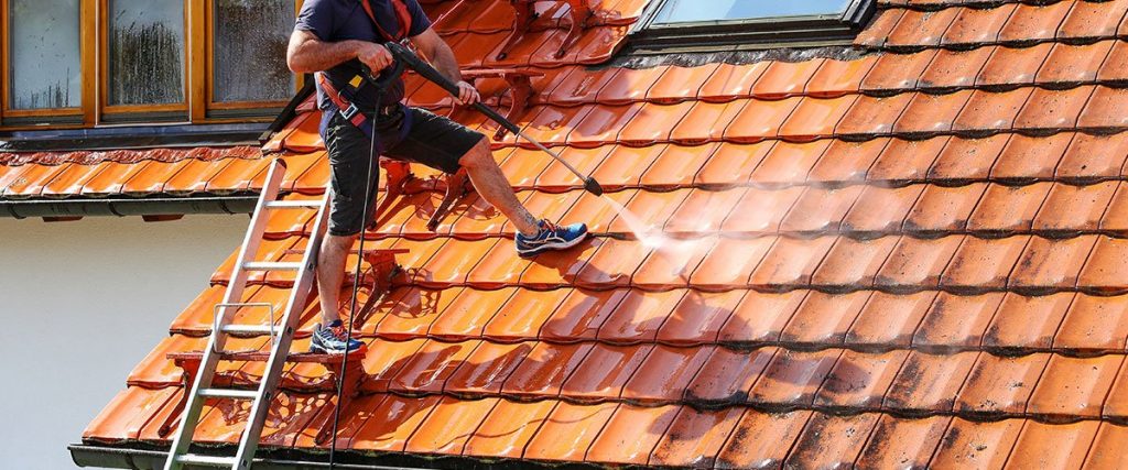 Nettoyage de toit en tuiles orangées au nettoyeur haute pression par marty-louis, couvreur dans le Tarn
